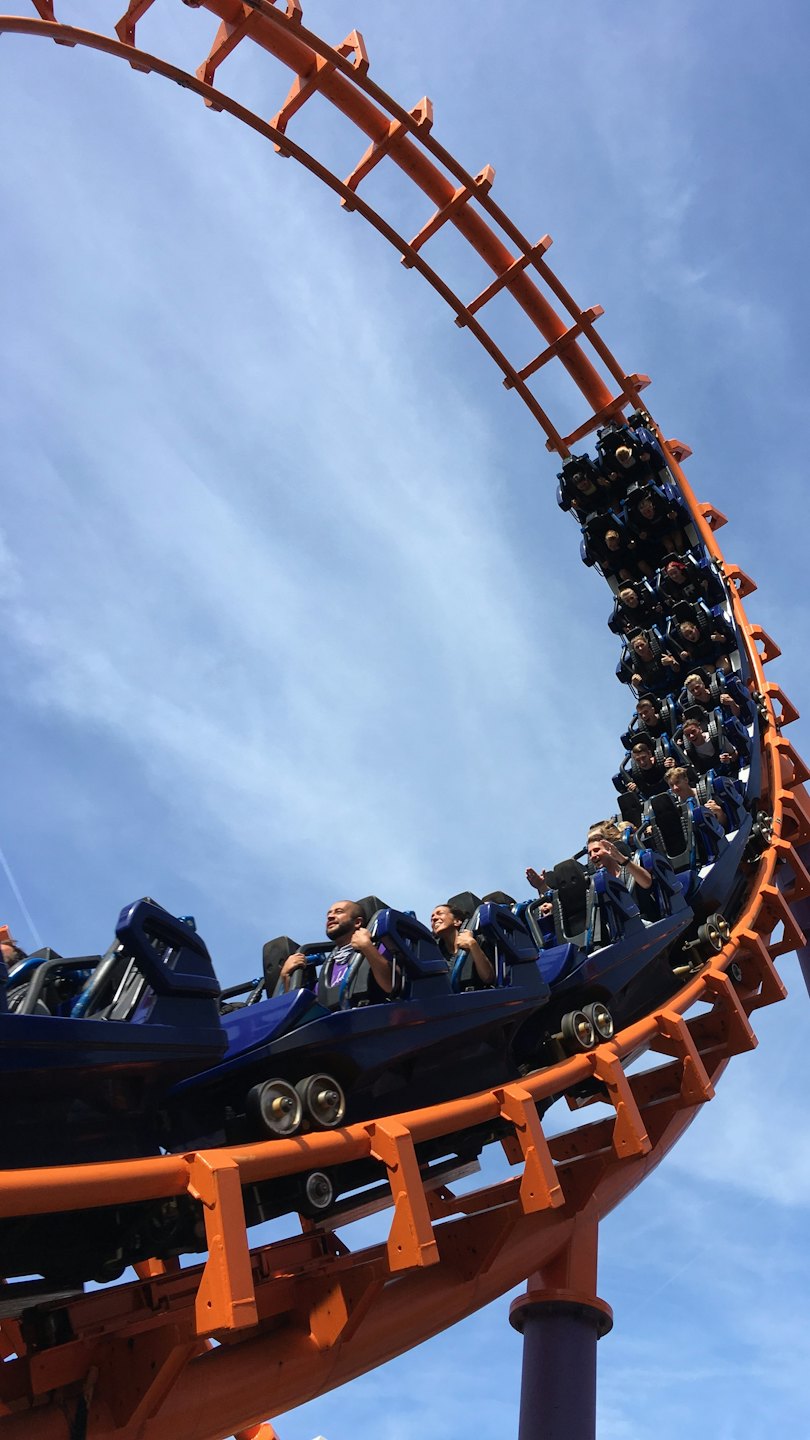 People scream with excitement on a blue roller coaster.