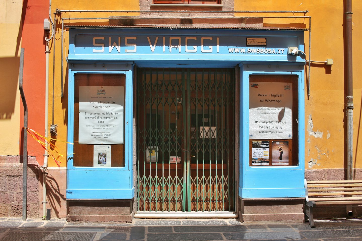 Travel agency storefront with a closed green security gate.